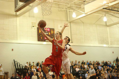 JUNIOR GUARD Andrew Miller (#3) goes up for a shot as Marblehead’s Justin Faia (#12) goes up to try and block the shot. Miller led Wakefield in scoring with 13 points. (Donna Larsson Photo)