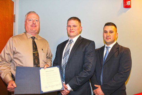 POLICE CHIEF David Breen (left) recommended the promotion of patrol officer Christopher DeCarlo (center) to sergeant and the appointment of Alex Doto (right) to patrol officer after both candidates ranked highest on their respective exams and interviews. Both appointments were endorsed by the selectmen Monday and followed the retirement of Sgt. David Mayerson after a 40-year career. The proclamation the board presented to Mayerson in absentia is held by Breen. (Maureen Doherty Photo)