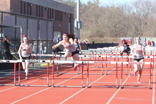 CHRISTINA FRENI, a senior captain (center), clears the hurdle in a recent Warrior meet. Freni ran a personal best in the 100 hurdles and made it to the finals in the Nashua North Invitational Meet on Saturday. (Donna Larsson File Photo)