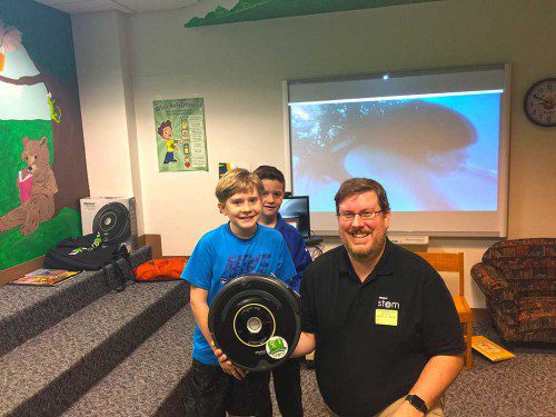 INTRODUCING "Andy the robot," a Roomba 650 that was donated to the HHS Maker Space to provide hands-on robotic exploration for students by iRobot engineer Andy String, shown with his son, Neal (left) and his second-grade classmate Luke Moschella following String's STEM presentations to students last week. (Courtesy Photo)
