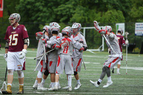SEVERAL MEMBERS of the WMHS boys’ lacrosse team celebrate as the Warriors beat Newburyport by an 18-5 score to cap off an undefeated regular season with an 18-0 record. (Donna Larsson Photo)