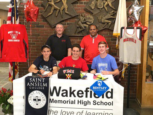 THREE WARRIORS, Ryan Sullivan (left, front), Nick McGee (right, front), and Adam Roberto (center, front) recently committed to compete at the college level after successful high school careers. In the back row are coaches Perry Pappas (left) and Ruben Reinoso (right). The three Warriors all were major contributors to the Div 4 Eastern Mass. State Championship Cross Country team as well as the 4x800 team this indoor season that went to Nationals and set the school record. They each helped the indoor team place second at the D4 State Championship by scoring in their individual events and combining to capture first place in the 4x800 relay at the same meet. They had major roles in both cross country and indoor track Middlesex League championship titles and were league all-stars for both seasons. Sullivan will become a member of the Saint Anselm’s Hawks cross country team, McGee will become a member of the Bentley University Falcons cross country and track and field teams, and Roberto will become a member of the Keydets track and field team at the Virginia Military Institute.