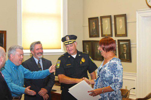 TAMI GOODHUE means a lot to the City of Melrose, and officials let her know it last week. From the left are state Rep. Paul Brodeur (partially obscured), Mayor Rob Dolan, Ward 6 Alderman Peter Mortimer, Police Chief Mike Lyle and Tami Goodhue.