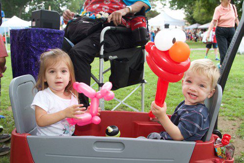 TWO-YEAR-OLD twins Grace and Jason Kelley proudly display the toy balloons they got at the Wakefield Farmers Market on Saturday. (Donna Larsson Photo)