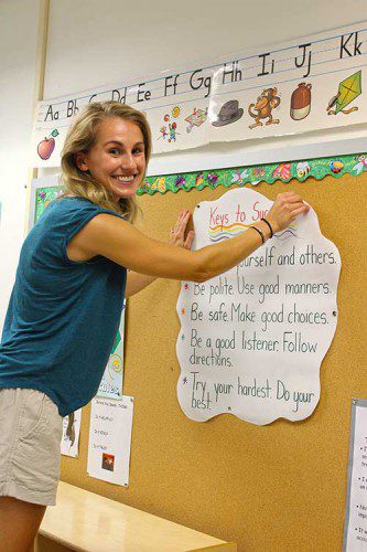 FIRST GRADE teacher Jennifer Moore hangs a poster in her Summer Street School classroom in preparation for the first day of school. Students return to school on Wednesday, Aug. 30. (Keith Curtis Photo)