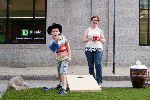 EIGHT YEAR OLD James Keenan plays beanbag horseshoes against his mother Joyce during the Chamber of Commerce's Summer Stroll Friday, July 28. (Donna Larsson Photo)