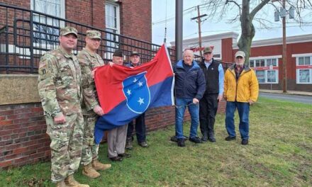 Bob Vincent gives Americal Division flag to town